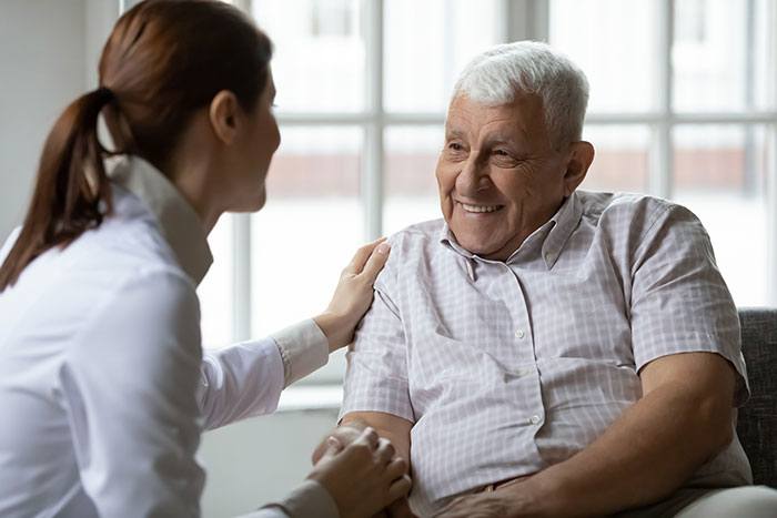 Woman talks with elderly man.