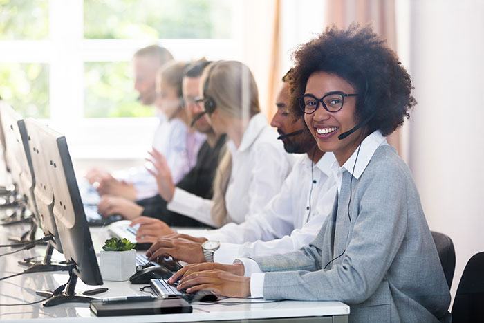 Customer service agents with headsets and laptops.