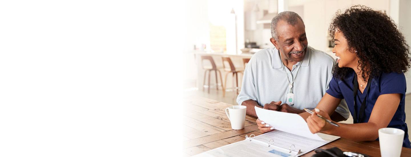 Nurse helps older gentlemen with paperwork.