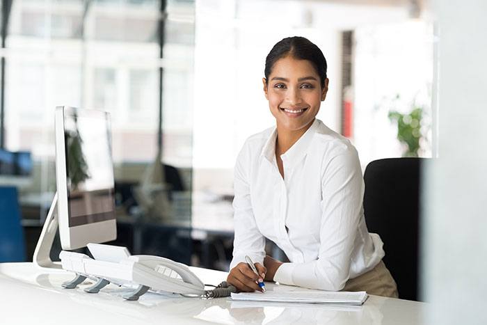 Friendly woman working at a desk.